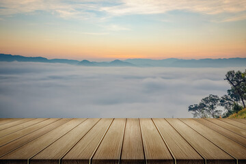 Fototapeta na wymiar Wooden table and mist mountains landscape in morning sunrise orange color sky
