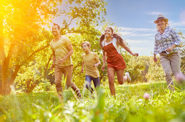 Laughing family with children running in the garden