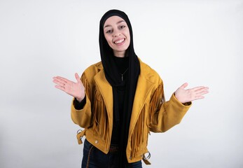 So what? Portrait of arrogant young beautiful muslim woman wearing hijab and yellow jacket over...