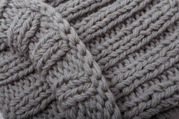 Knit grey fabric texture, background or backdrop. Textile, scarf or sweater textured surface. Warm accessories, clothing, fashion concept.