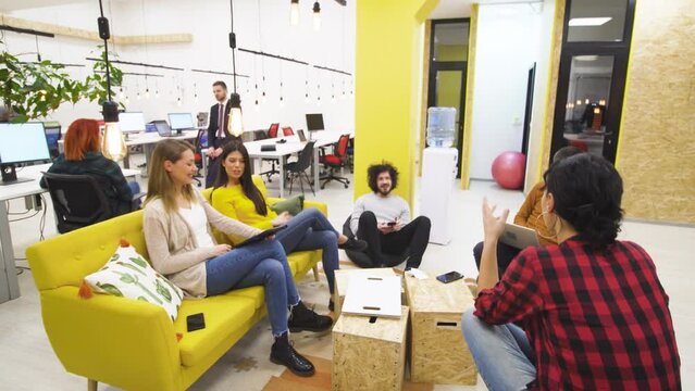 Seven creative young individuals brainstorming in a modern office space. Successful startup company meeting.