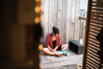 Girl painting holding the canvas with her feet