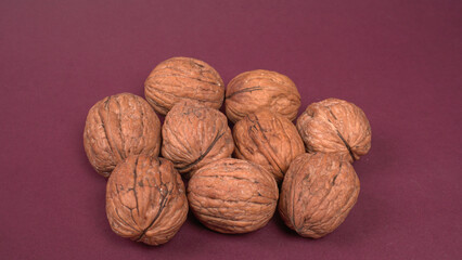 Closeup photo of a walnut seed in wooden bowl. Food that is good for brain and lower risk of heart disease.