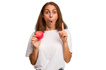 Young caucasian woman holding a red apple isolated having some great idea, concept of creativity.