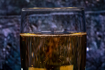Bubbles in a glass of champagne, on a dark background, macro photography