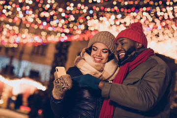 Photo of pretty sweet husband wife wear winter season clothes typing device xmas noel greetings outside urban city street