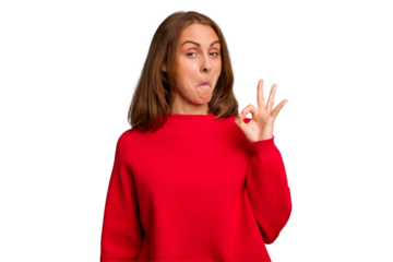 Young caucasian woman isolated winks an eye and holds an okay gesture with hand.