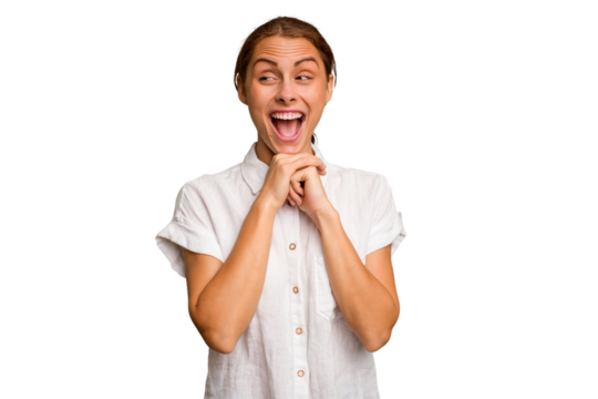 Young caucasian woman isolated keeps hands under chin, is looking happily aside.