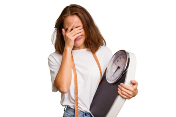 Young nutritionist caucasian woman holding scale and mesure tape isolated