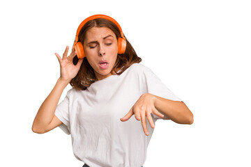 Young caucasian woman listening to music with headphones isolated