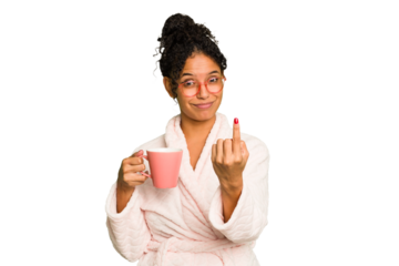 Young brazilian woman wearing a pajama holding a cup isolated pointing with finger at you as if inviting come closer.