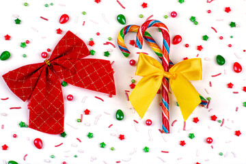Christmas background of colorful candies, candy canes and bows, on a white background, close-up