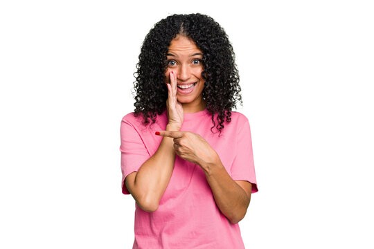 Young cute brazilian woman isolated saying a gossip, pointing to side reporting something.