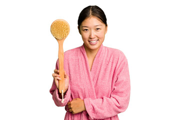 Young asian woman holding a shower brush isolated laughing and having fun.