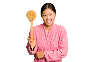 Young asian woman holding a shower brush isolated laughing and having fun.