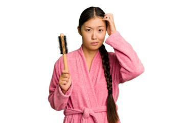 Young asian woman holding an hair comb isolated being shocked, she has remembered important meeting.