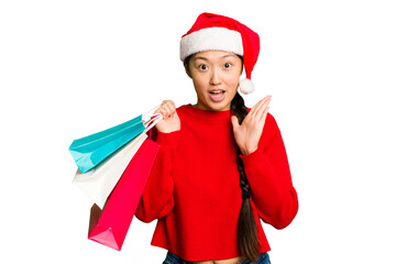 Young asian woman shopping a christmas presents isolated Young asian woman shopping a christmas presents isolated surprised and shocked.
