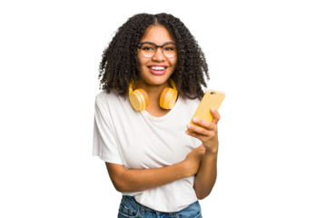 Young african american woman listening to music with yellow headphones isolated laughing and having fun.