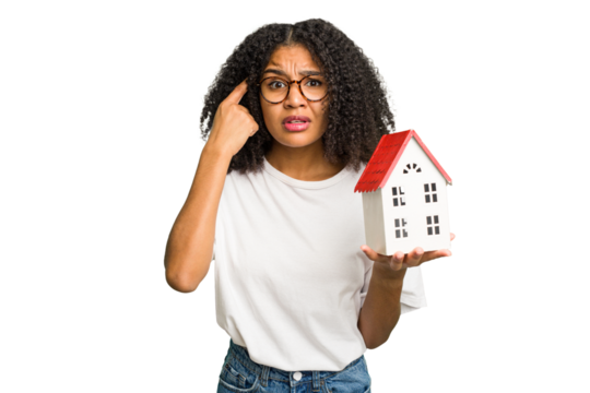 Young african american woman moving to a new home while picking up a box full of things isolated showing a disappointment gesture with forefinger.