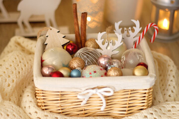 Basket with various Christmas ornaments and knitted blanket. Selective focus.