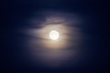 Full moon with clouds at twilight, purple cast