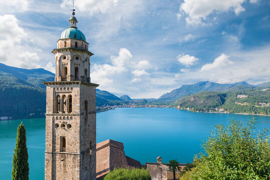 Big Swiss lake. Lake Lugano from Morcote with the bell tower of the Santa Maria del Sasso church in the foreground and the Italian town of Porto Ceresio in the background