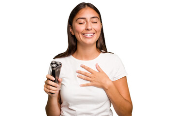 Young caucasian woman holding a razor isolated laughs out loudly keeping hand on chest.