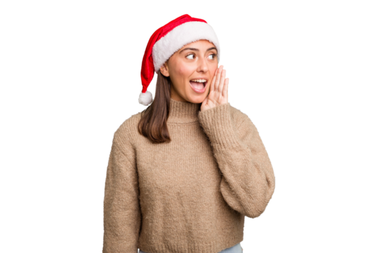 Young caucasian woman celebrating christmas wearing a santa hat isolated shouting and holding palm near opened mouth. - Powered by Adobe