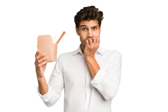 Young caucasian man holding a takeaway of noodles isolated biting fingernails, nervous and very anxious.