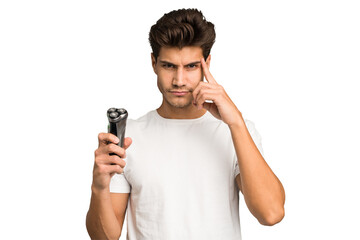 Young caucasian man holding a razor isolated pointing temple with finger, thinking, focused on a task.