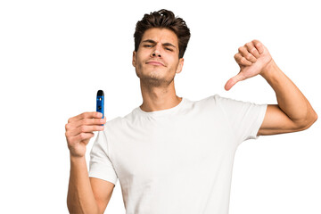 Young caucasian man holding an electronic cigarette isolated feels proud and self confident,...