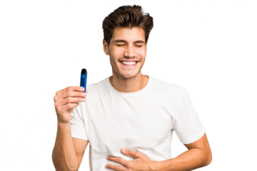 Young caucasian man holding an electronic cigarette isolated laughing and having fun.