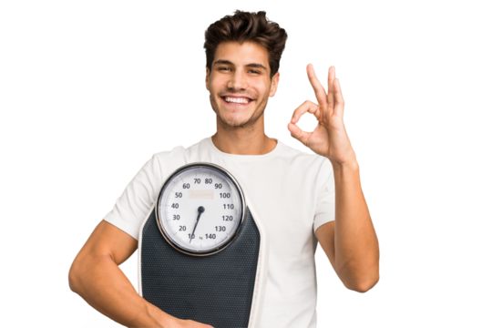 Young caucasian man holding a scale isolated cheerful and confident showing ok gesture.