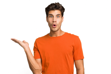 Young caucasian handsome man isolated impressed holding copy space on palm.