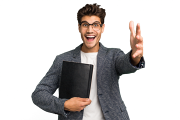 Young teacher caucasian man holding a book isolated receiving a pleasant surprise, excited and raising hands.