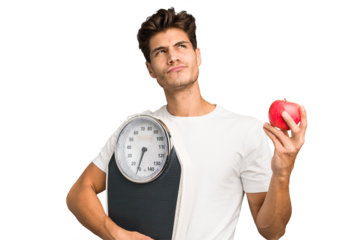 Young caucasian man holding a scale and an apple isolated