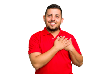 Young caucasian man isolated has friendly expression, pressing palm to chest. Love concept.