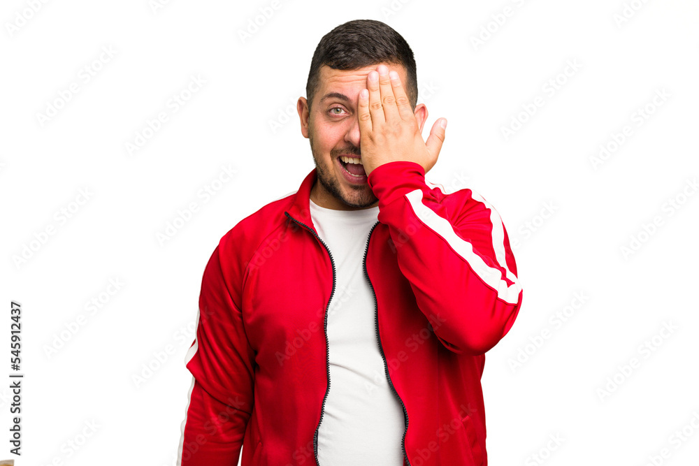 Canvas Prints Young caucasian man isolated having fun covering half of face with palm.