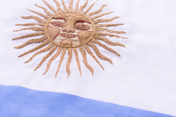 Argentinian flag with embroidered golden sun. - obrazy, fototapety, plakaty