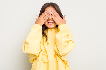 Young Indian woman isolated on white background covers eyes with hands, smiles broadly waiting for a surprise.