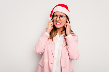 Business caucasian woman wearing a christmas hat isolated on white background covering ears with hands.