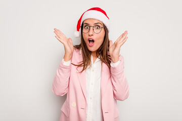 Obraz na płótnie Canvas Business caucasian woman wearing a christmas hat isolated on white background surprised and shocked.