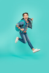 Energetic teenager screaming in midair, school. Excited girl jumping after school