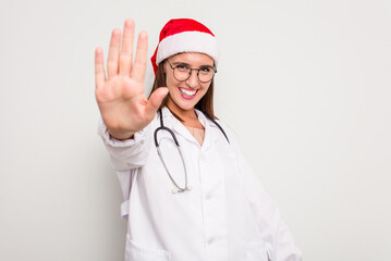Young caucasian doctor woman wearing a santa hat isolated on white background