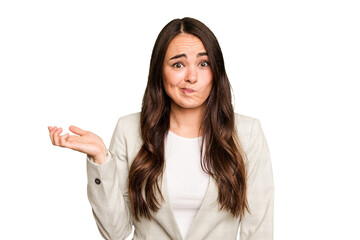 Young caucasian woman isolated on green chroma background doubting and shrugging shoulders in...