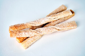 Puff pastry sticks with cinnamon on white background