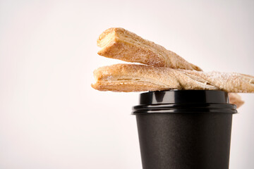 Paper coffee cup and Puff pastry sticks, close-up