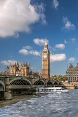 Fototapeta na wymiar Famous Big Ben with bridge over Thames and tourboat on the river in London, England, UK
