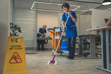 Cleaners clean an office space - obrazy, fototapety, plakaty