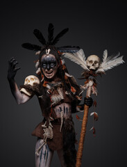 Shot of screaming dark sorcerer dressed in aboriginal attire against grey background.